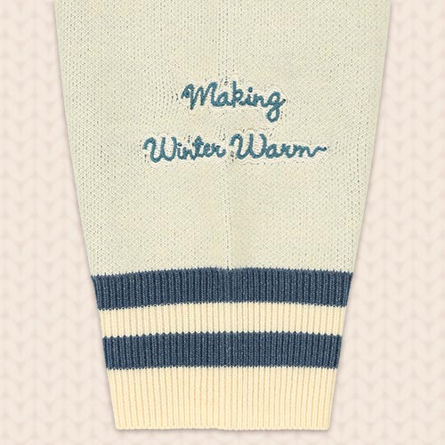 袖の拡大。「Making Winter Warm」の文字と、袖口の青系のライン、表面の編み目が見えます。